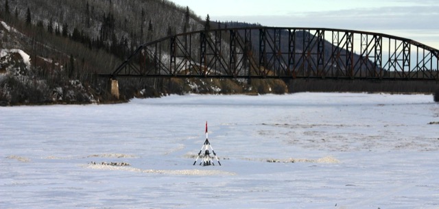 The Nenana Ice Classic tripod standing on the frozen Tanana River in front of the railroad bridge